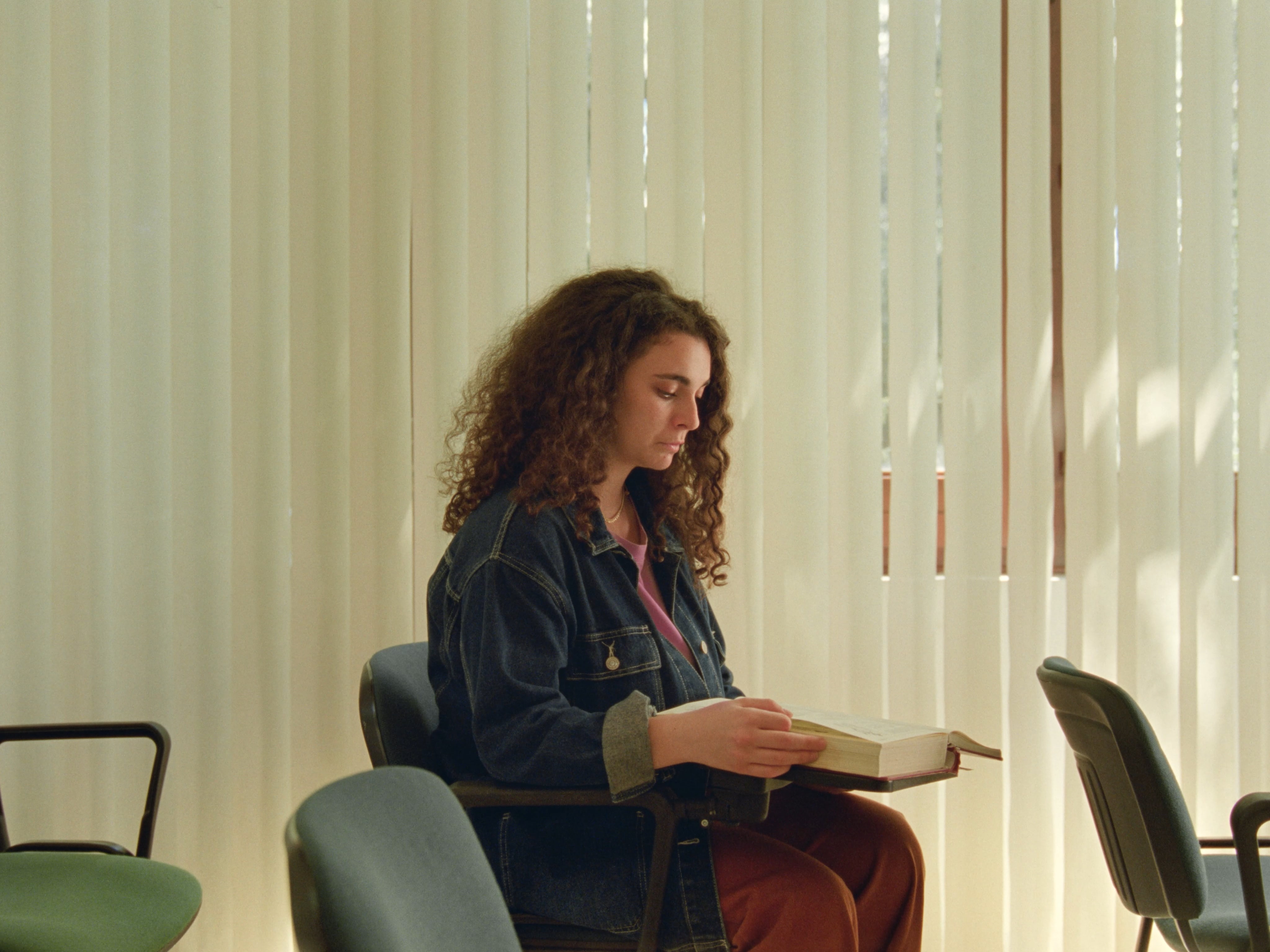 Woman sitting in a classroom reading a book